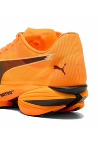 Puma hardloopschoen met een levendige oranje meshe bovenkant, zwarte accenten, een gevoerde zool en een slank ontwerp met NITRO elite branding.