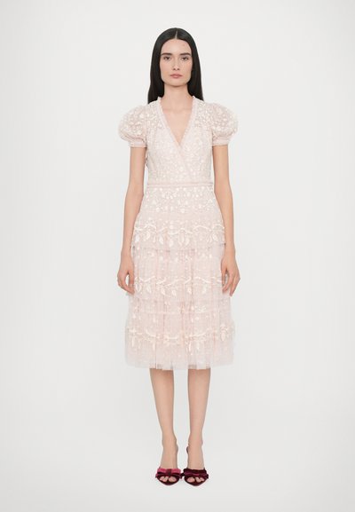 Helles rosa, knielanges Kleid mit Puffärmeln, V-Ausschnitt, bestickten Blütendetails, gestuften Rüschchen und einem Stoffbindegürtel. Samtschuhe mit Schleifen.