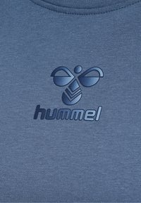 Granatowa koszulka T-shirt z teksturowanym logo z napisem "hummel" i stylizowanymi akcentami powyżej. Gładki materiał z okrągłym dekoltem.