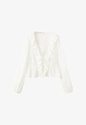 Blouse blanche à manches longues avec un décolleté en V profond, bordure à volants le long de l'encolure et de l'ourlet, et une fermeture à nouer à l'avant.