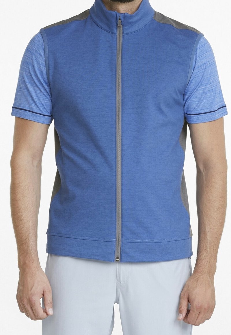 Kortärmad zip-up väst i ljusblått med grå accenter. Texturerat tyg; har ståkrage och kontrasterande mönster på ärmarna.