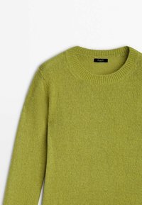 Pull vert en maille avec un col rond, des poignets côtelés et une texture douce. Étiquette visible au niveau du col.