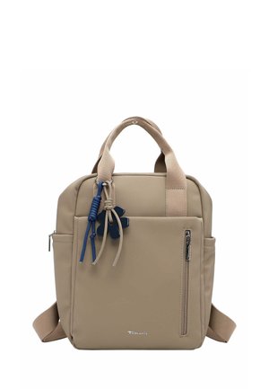 Zaino quadrato beige con manici superiori, tasca frontale con cerniera, tasche laterali e cordoncini decorativi blu e beige con ciondolo a forma di fiore.