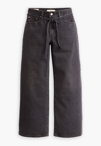 Jean noir à jambes larges avec taille haute, bouton et fermeture éclair à l'avant, passants pour ceinture et ceinture en tissu nouée à la taille.