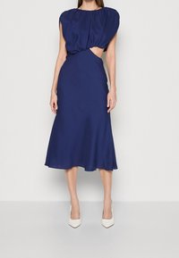 Mörkblå midi-klänning med puffärmar, texturerad bodice och ett utskärningsdetalj i midjan. Slät tyg med en utsvängd nederkant.