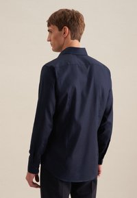 Camicia a maniche lunghe navy con colletto classico, vestibilità sagomata e dettagli con bottoni sui polsini, realizzata in un tessuto liscio con finitura opaca.