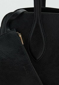Black textured leather handbag with rounded handles and a matching zippered pouch partially inside the bag.