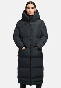 Lunga giacca a vento nera con collo alto, chiusura con zip, grandi tasche e texture trapuntata. Presenta una silhouette aderente e un cappuccio oversize.