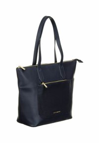 Sac fourre-tout en cuir bleu marine avec deux poignées, poche avant zippée et accents de fermeture éclair dorés, debout sur un fond blanc.