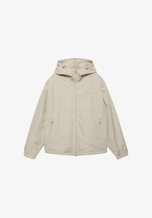 Giacca beige con cappuccio, cerniera frontale, due tasche con cerniera, polsini elasticizzati e piccolo logo sul petto.