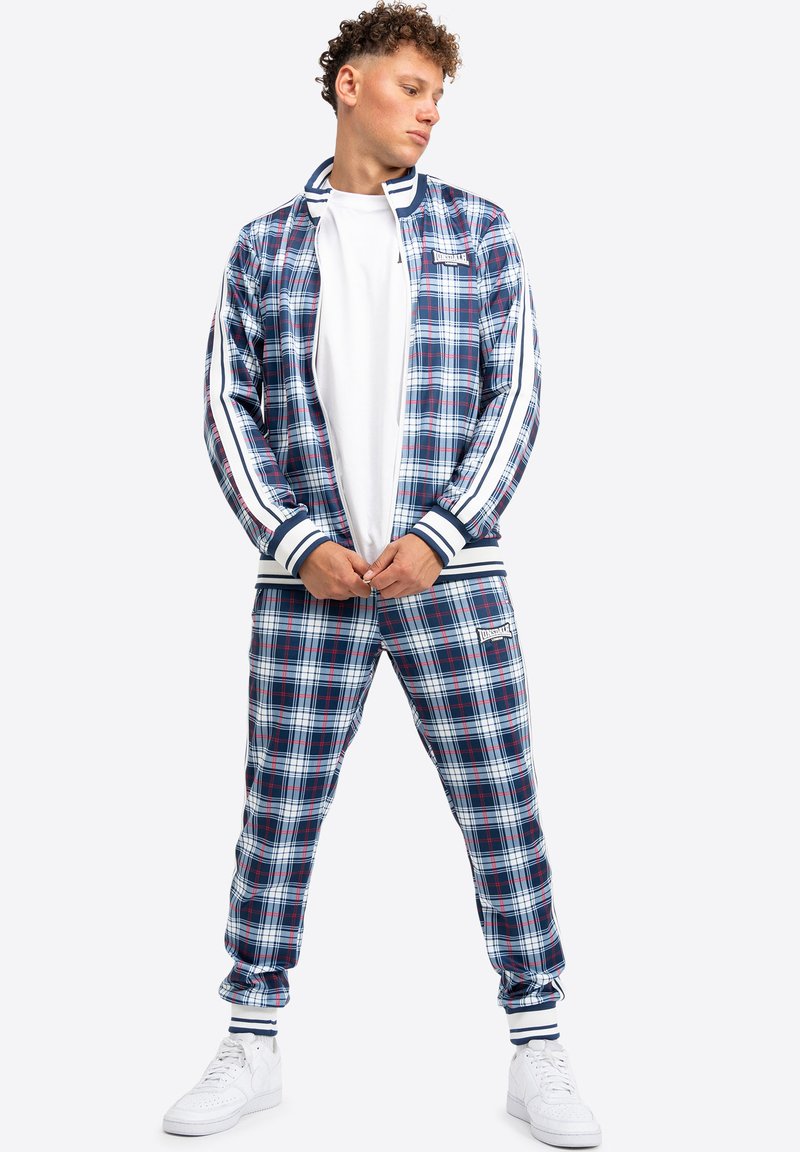 Karierter Trainingsanzug in Blau, Rot und Weiß; mit gestreiften Bündchen und Details; beinhaltet eine Reißverschlussjacke und passende Hose.