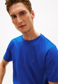 Μπλε βαμβακερό μπλουζάκι με κοντά μανίκια και στρογγυλή λαιμόκοψη. Διαθέτει μικρό λογότυπο κεντημένο στο στήθος σε κόκκινο, λευκό και μπλε χρώμα.