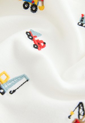 Hvidt stof med farverige broderede mønstre af køretøjer, herunder en blå lastbil, en rød bil og gult entreprenørudstyr.