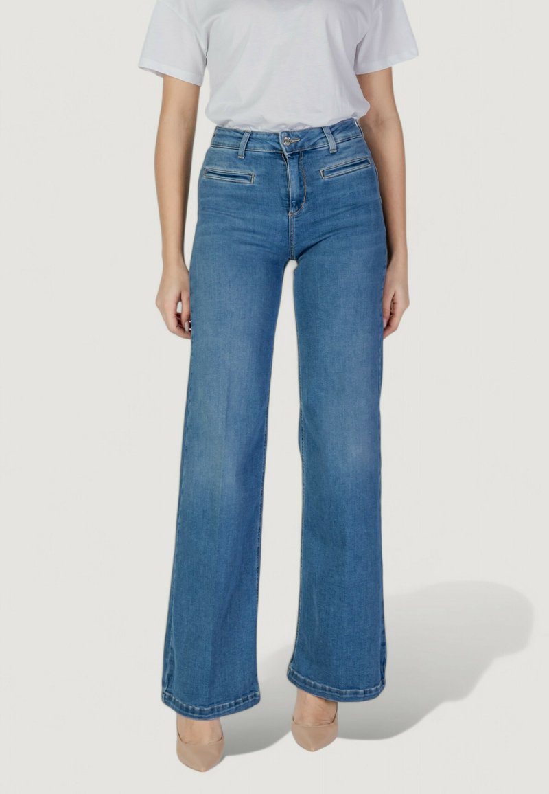 Jeans de tiro alto en un azul claro, con un diseño de pierna ancha. Presentan dos bolsillos delanteros y costuras visibles a lo largo de los dobladillos. Tela de denim texturizada.