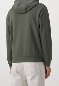 Felpa con cappuccio verde scuro, materiale morbido, maniche lunghe, polsini e orlo a coste. La vista posteriore mostra un design liscio e senza decorazioni.