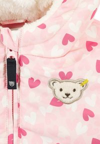Veste isolante rose avec un motif de cœurs, une doublure douce et un visage de panda brodé avec un accent jaune sur la capuche.
