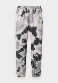 Μαύρο-λευκά παντελόνια φόρμας με σχέδιο tie-dye, με ελαστική μέση και τελειώματα, σε απλό φωτεινό φόντο.