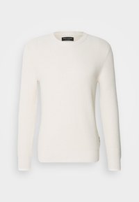 Cremefarbener, gerippter Pullover mit langen Ärmeln, rundem Ausschnitt und strukturierter Stoffqualität. Mit Logoband an der Seite.
