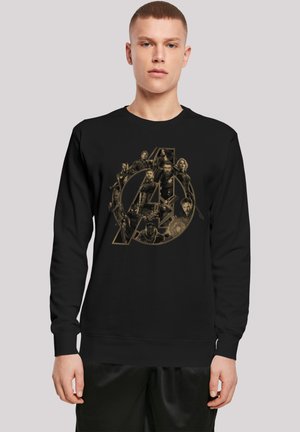 Must värvitud musta dressipluus, millel on suur kuldne „A” logo ning erinevad tegelaste pildid Avengers'ist. Materjal näib olevat pehme ja tekstuuriline.