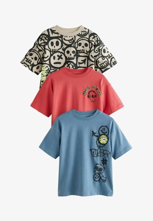 Három grafikai póló: egy fekete, koponya mintákkal, egy piros, koponyával és fejhallgatóval, valamint egy kék, játékos grafikákkal és szöveggel.