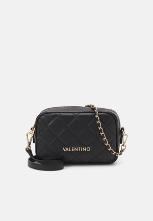 Borsa a tracolla in pelle nera trapuntata con hardware dorato, dotata di una tracolla a catena e dettaglio del logo sul fronte. Chiusura con zip.