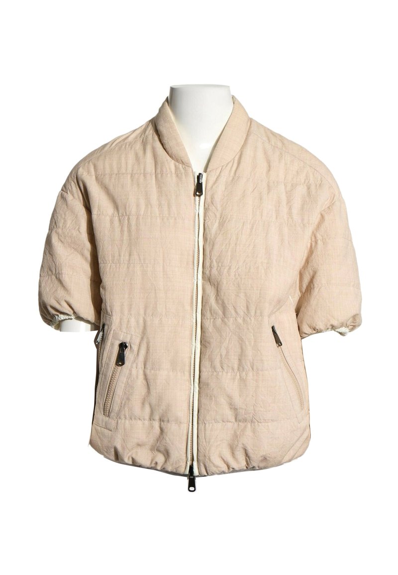 Veste matelassée beige clair à manches courtes avec fermeture éclair frontale et deux poches zippées, présentée sur un buste de mannequin blanc.