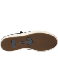 Semelle de chaussure en caoutchouc avec un motif brun texturé. Présente un bord blanc et un design de flèche proéminent pointant vers le haut. Nom de la marque visible.