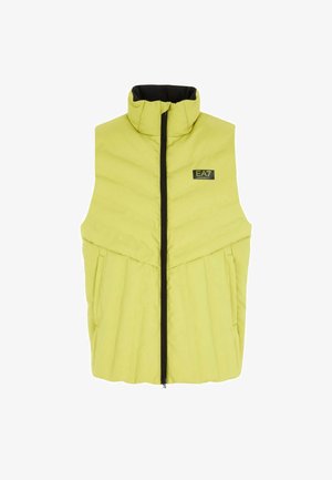 Rumena pufasta brezrokavnica z visokim ovratnikom, sprednjim zadrgo in črnimi detajli. Ima dva stranska žepa in logotip na predelu prsi.