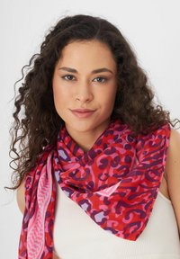 Lichtgewicht, multicolore sjaal met een gedurfde, abstracte luipaardprint in rode, paarse en roze tinten, met een zachte textuur.