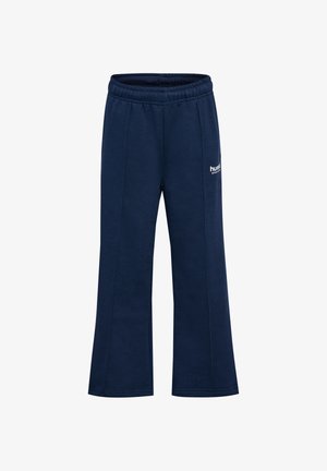 Granatowe dresy z elastycznym paskiem w talii, szerokimi nogawkami i subtelnym przeszyciem po bokach. Na lewej udzie znajduje się białe logo.