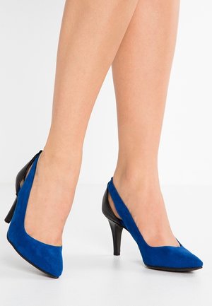 Escarpins à talons hauts en daim bleu avec bout pointu et côtés découpés. Talon noir brillant pour un contraste marqué. Texture lisse qui valorise l'aspect visuel.