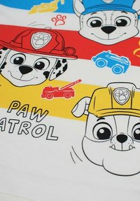 Tissu sur le thème de Pat' Patrouille, présentant des chiens dessinés animés aux couleurs rouge, bleu, jaune et blanc, avec des expressions ludiques et des véhicules, y compris un camion de pompiers.