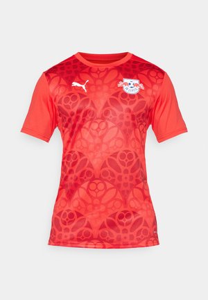 Raudona sportinė maikutė trumpomis rankovėmis su tekstūruotu raštu. Ant kairiojo krūtinės pusės yra balta Puma logo ir komandos emblema. Lengvas medžiaga.