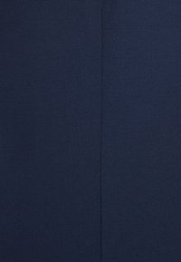 Marineblauer Stoff mit glatter Textur, der ein feines Webmuster aufweist und eine mittig verlaufende Naht, die vertikal durch die Mitte führt.
