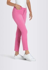 Jean skinny en denim rose avec un détail zip à la cheville. Fabriqué en tissu extensible, il présente un design classique à cinq poches et une taille mi-haute.