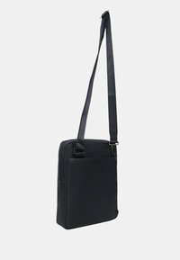 Mørk marineblå messenger taske lavet af læder, med en skulderrem, rektangulær form og frontlomme. Glat tekstur, minimalistisk design.