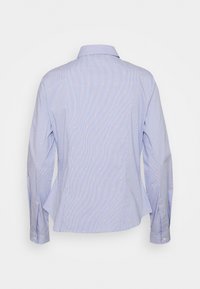 Camicia azzurra a maniche lunghe con sottili righe e una piccola fantasia a pois arancioni, mostrata da dietro su sfondo bianco.