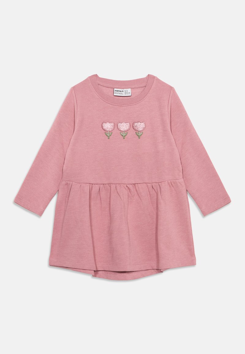 Robe bébé rose à manches longues avec taille froncée et trois fleurs roses brodées avec tiges vertes sur la poitrine.
