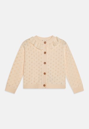 Licht perzik gebreide cardigan met een gestructureerd patroon, een rimpelcollar en vijf ronde bruine knopen aan de voorkant.