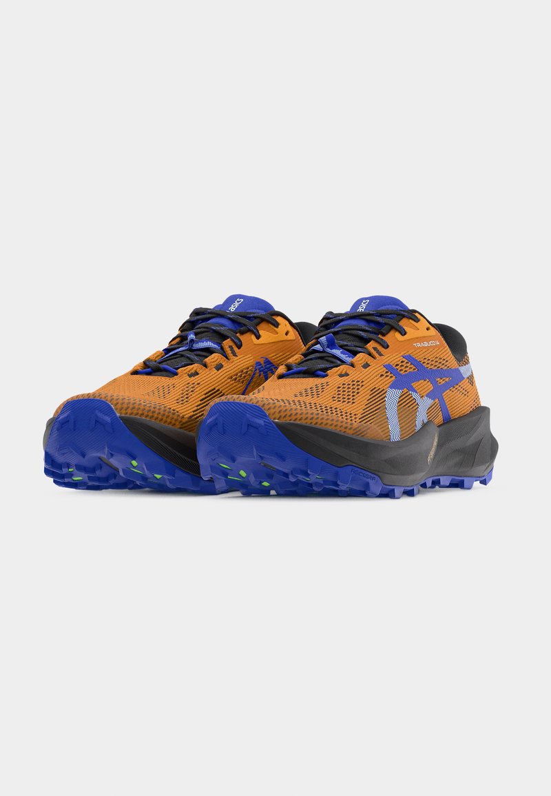 Chaussures de trail running orange et noires avec des accents bleus, tige en mesh, semelle extérieure texturée et crampons relevés pour la traction. Conception flexible et légère.