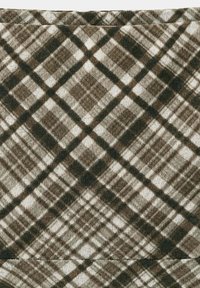 Tissu à carreaux beige et marron foncé avec des lignes diagonales qui se chevauchent formant un motif à carreaux et une couture visible près du haut.