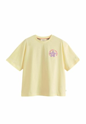 Hellgelbes T-Shirt mit kurzen Ärmeln, einer kleinen lila Blume und pinkfarbenem Text "Life in Full Colour" auf der oberen linken Brust.