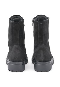 Stivaletti alla caviglia in suede nero con superficie testurizzata, caratterizzati da una punta rotonda e una suola in gomma resistente. Chiusure con zip sul retro e linguette per una facile apertura.