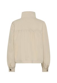 Šviesiai ruda, trumpa striukė su aukštu apykakle, elastingomis pūkuotomis rankovėmis ir raukšlėta nugaros detale. Pagaminta iš lygaus, lengvo audinio.