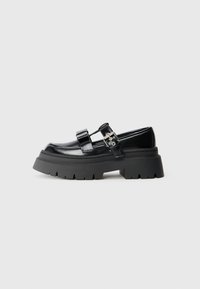 Chaussures en cuir verni noir avec une semelle épaisse, dotées de deux boucles réglables et d'un design à bout rond.
