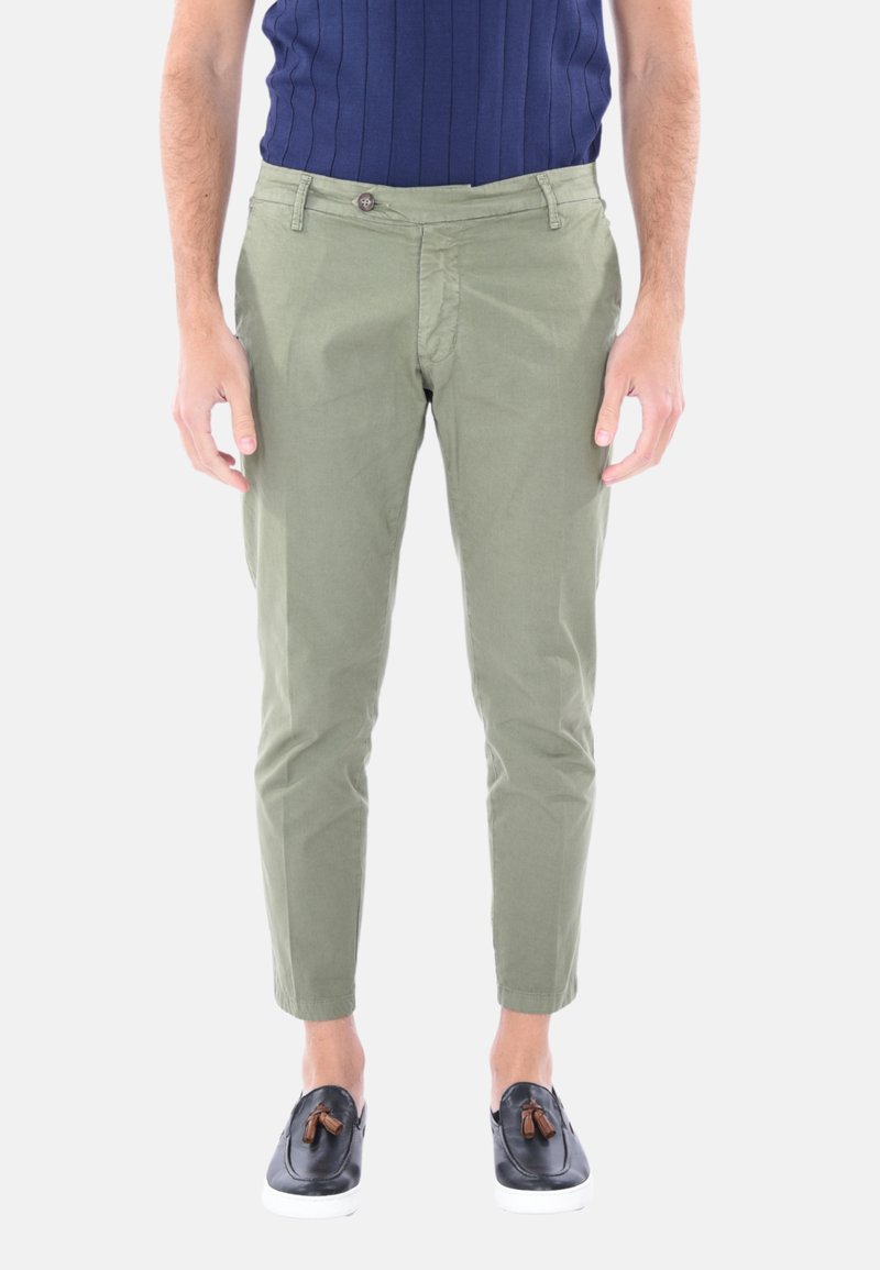 Chinos verde oliva con vestibilità slim, realizzati in cotone, dotati di chiusura a bottone e tasche. Abbinati a scarpe nere slip-on.