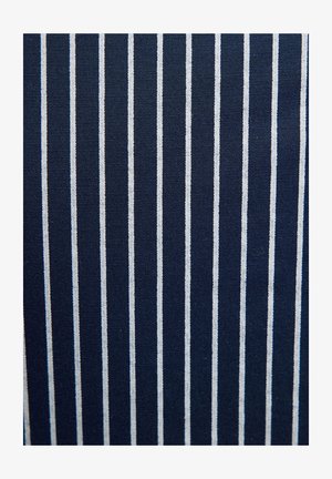 Mornarska tkanina s vertikalnim bijelim prugama, koja ima teksturiranu tkanje i ravnomjerno raspoređene pruge, stvarajući strukturirani, uzorčasti izgled.