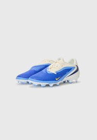 Blå fodboldstøvler med en tekstureret overdel, hvide accenter og gul swoosh. Har en formet sål med blå støvler for traction.