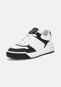 Baskets blanches et noires avec une tige en cuir texturé, des accents en mesh, une semelle intermédiaire blanche et une semelle extérieure en caoutchouc noir, avec un logo sur la languette.