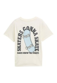 Krēmbalti kokvilnas T-kreklis ar viegli zilas skrituļdēļa grafiku un melnu tekstu, kas lasāms "SKATERS GONNA SKATE" un "ALWAYS SURFIN' THE STREETS."